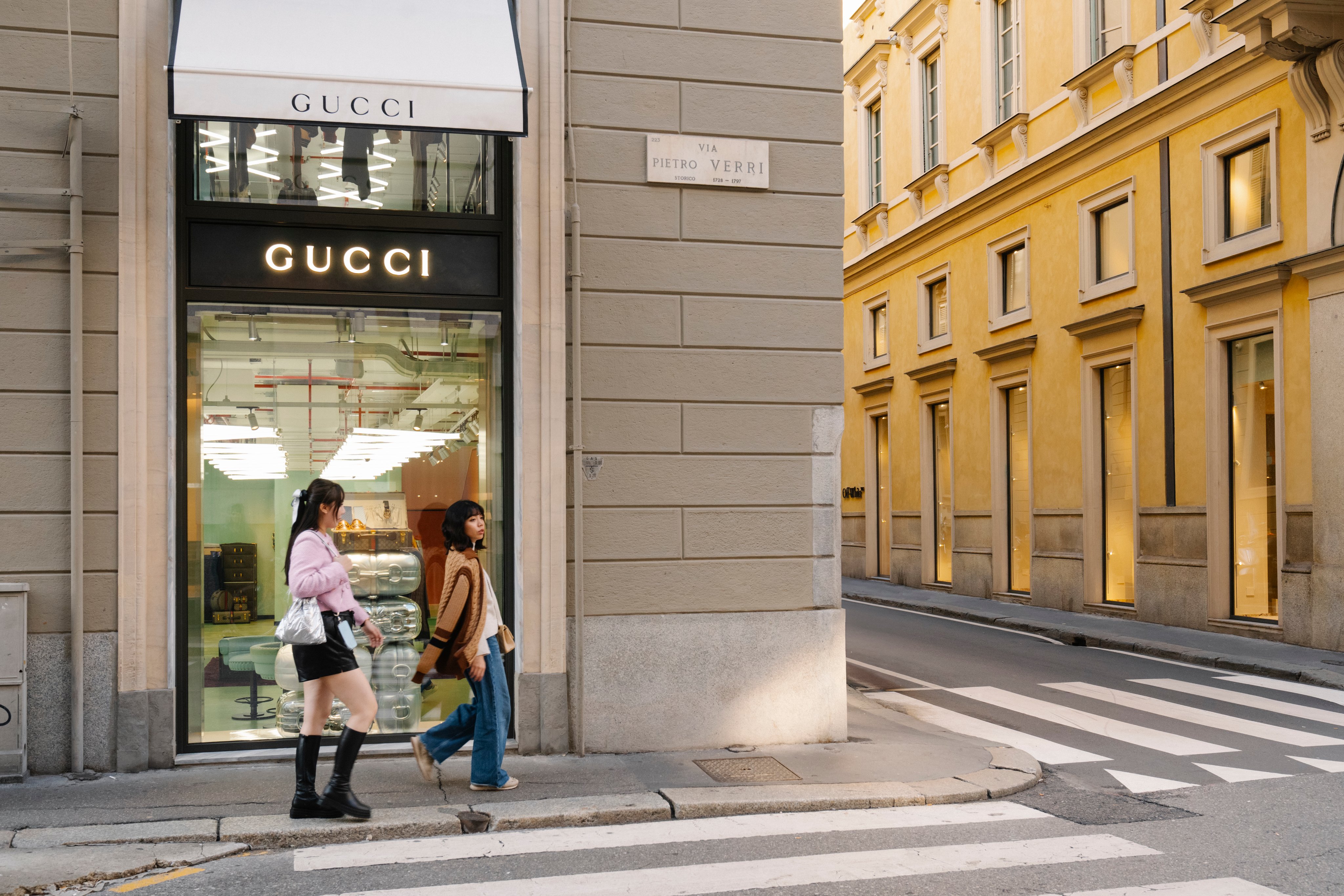 Negozio di Gucci all’angolo della strada. Due donne ci passano davanti.