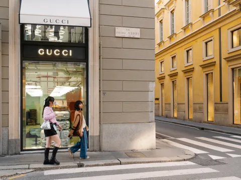 Negozio di Gucci all’angolo della strada. Due donne ci passano davanti.