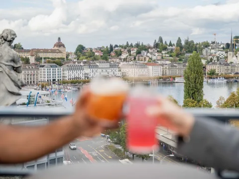 View of the city of Lucerne. Two cocktail glasses toasting in the foreground.