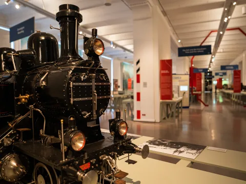 La miniatura di una vecchia locomotiva a vapore di colore nero in una delle sale espositive del Museo della tecnica di Vienna.