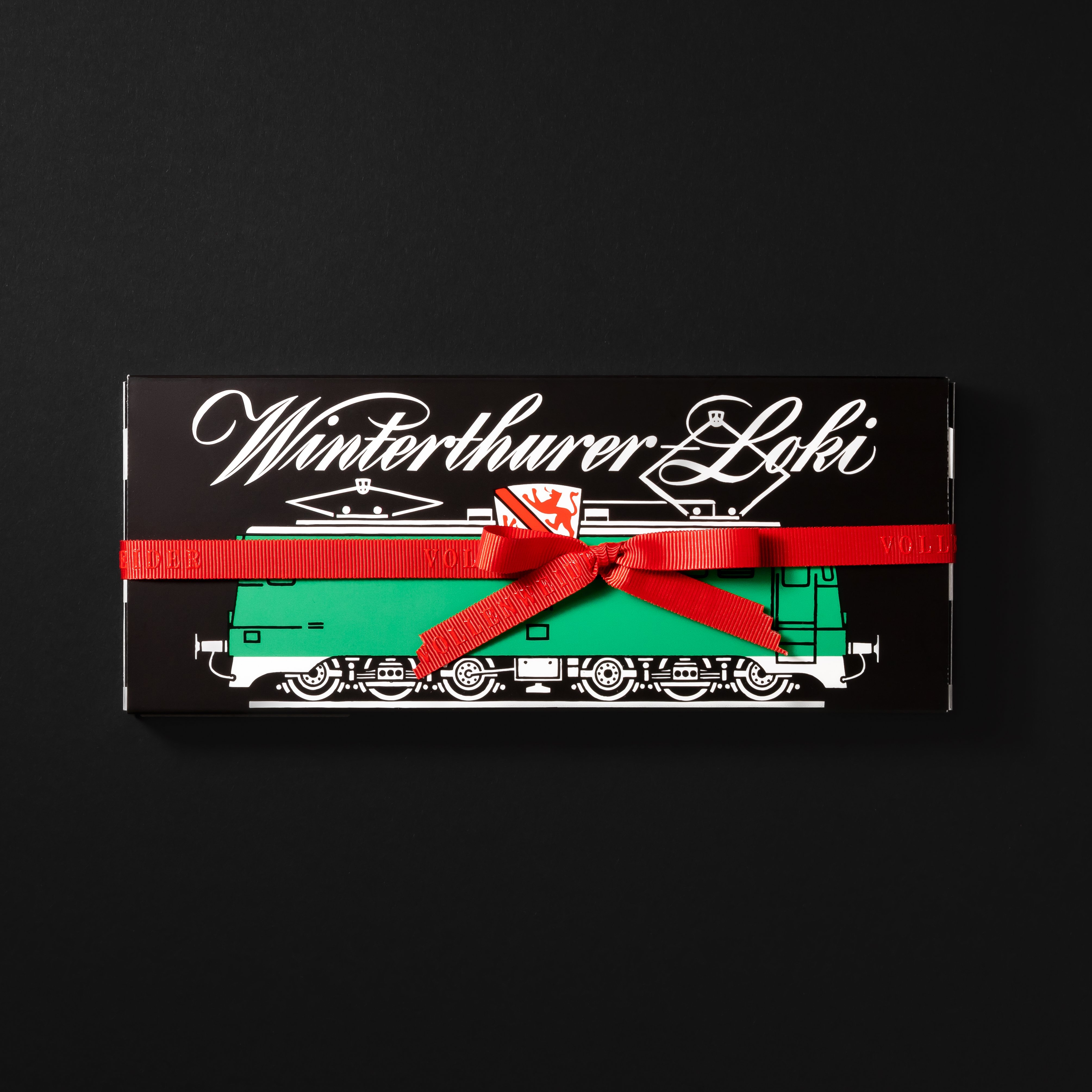 Emballage noir avec locomotive verte et inscription blanche «Winterthurer Loki».