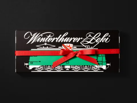 Emballage noir avec locomotive verte et inscription blanche «Winterthurer Loki».