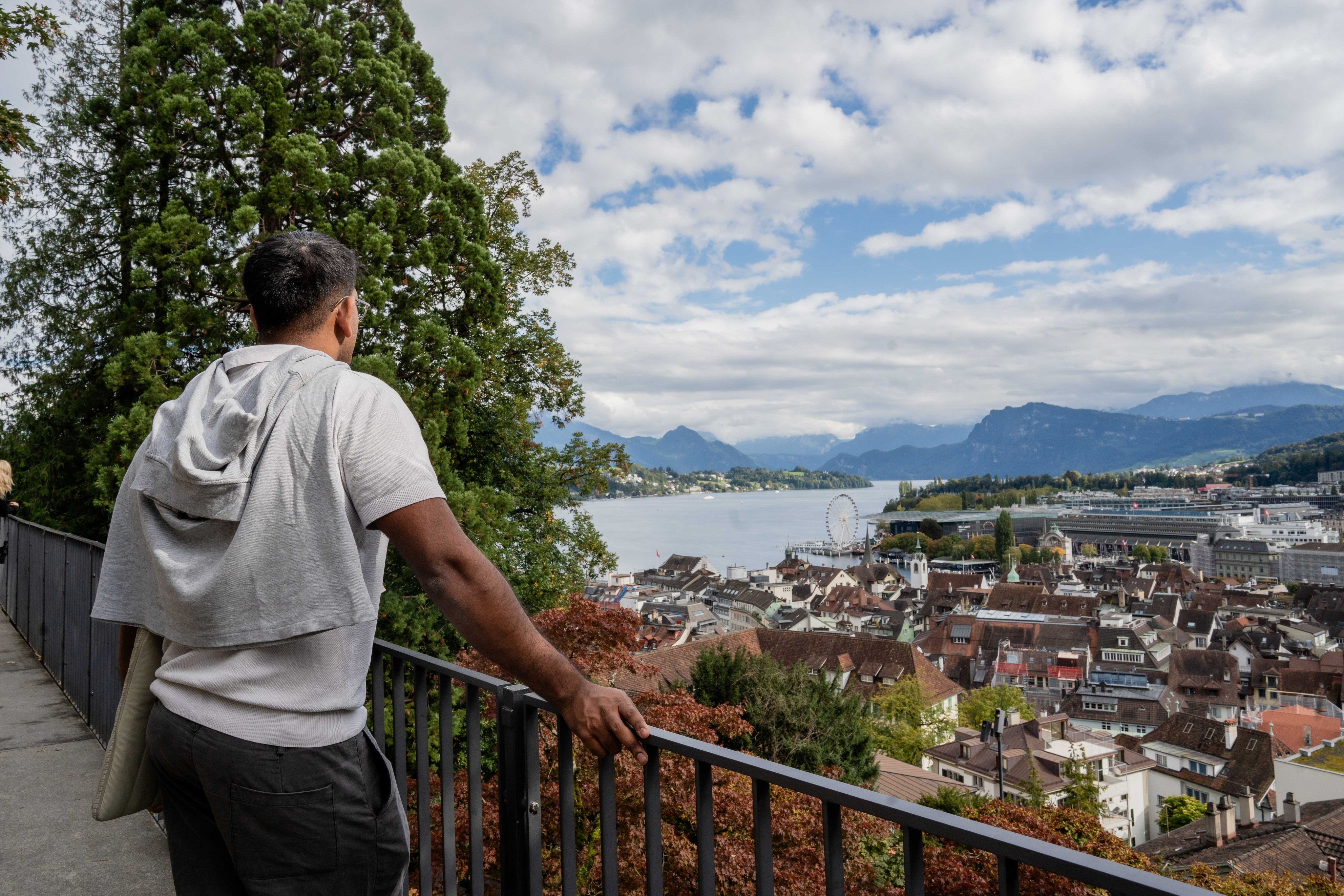 A man enjoys the view of the lake and the city.