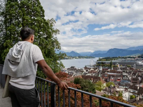 A man enjoys the view of the lake and the city.