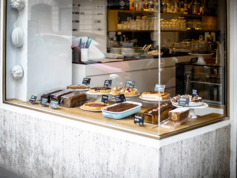 Im Schaufenster des Cafés stehen zwölfverschiedene Kuchen.