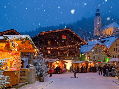 Verschneite Gasse mit Ständen am Salzburger Christkindlmarkt.