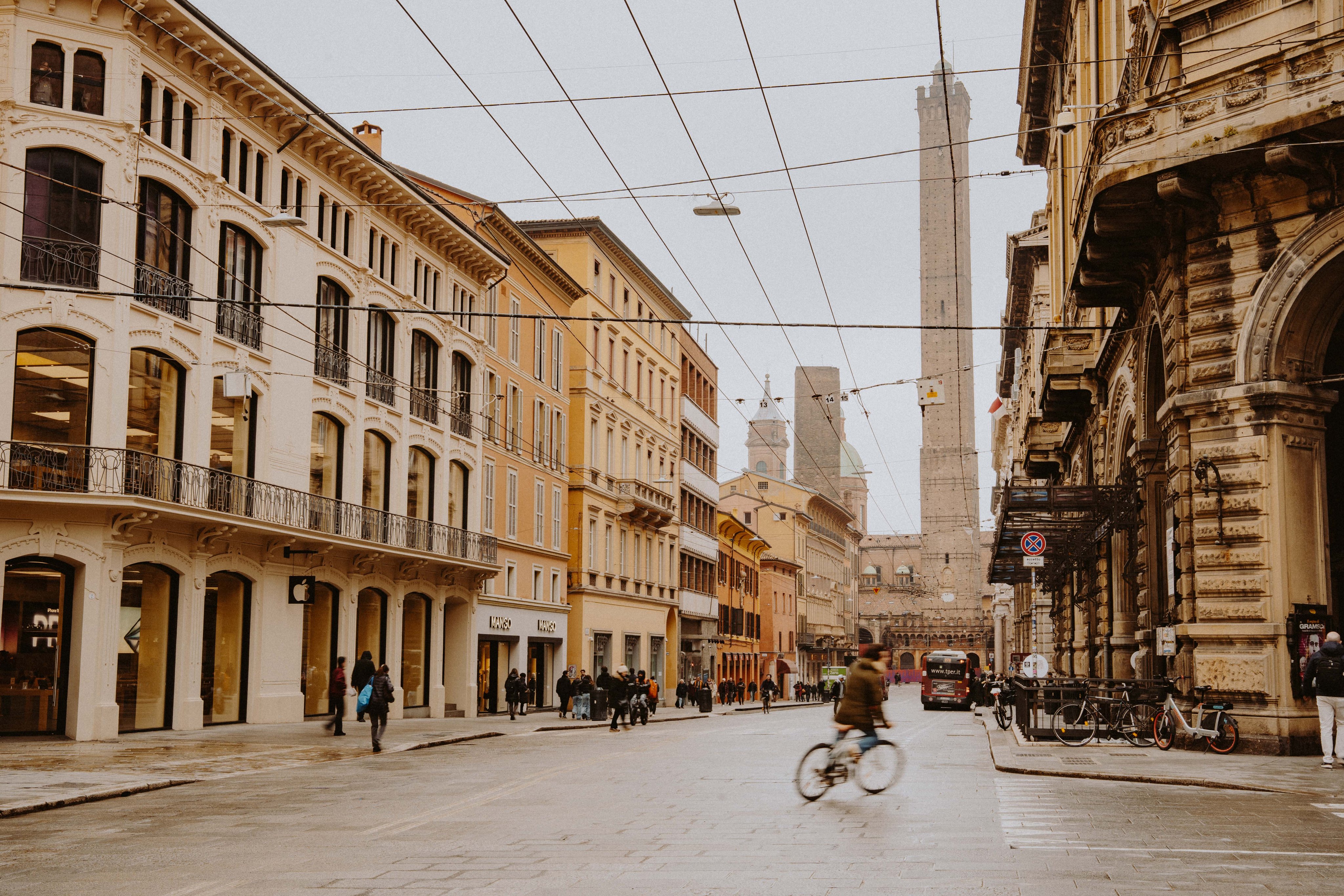 Lively street in Bologna with buildings and Asinelli Tower