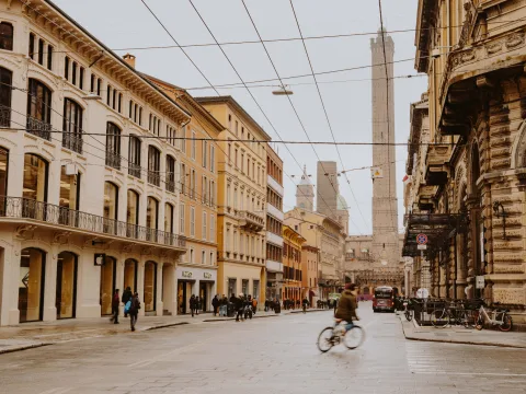 Lively street in Bologna with buildings and Asinelli Tower