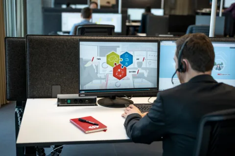 Un uomo che indossa delle cuffie sta guardando un computer.