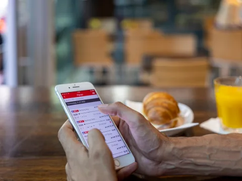 Eine Kundin kauft ein Billett mit ihrem Smartphone.