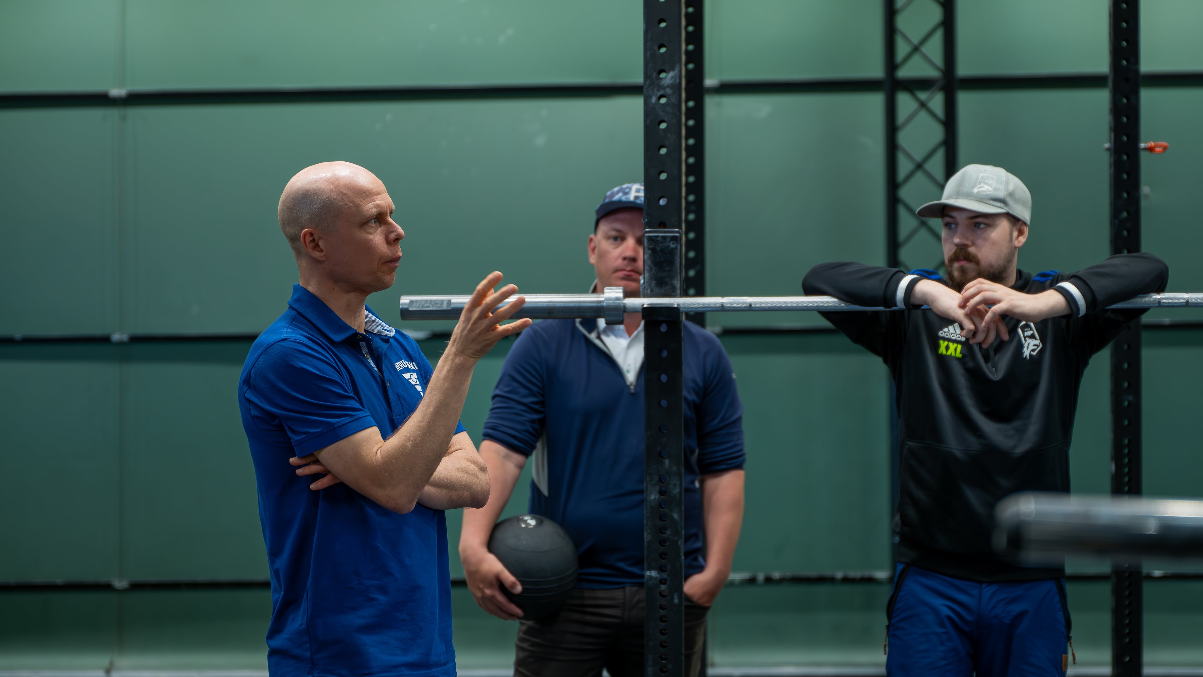 Kolme miestä kuntosalilla.