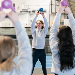 Ohjaaja kahvakuula kädessä ja kaksi asiakasta hänen edessään.