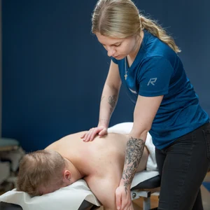 Hieroja hieromassa asiakkaan olkapäätä.