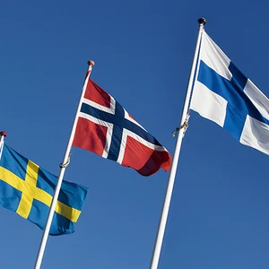 St1 finns i Sverige, Norge och i Finland. Bild på svenska, norska och finska flaggor som vajar mot en blå himmel