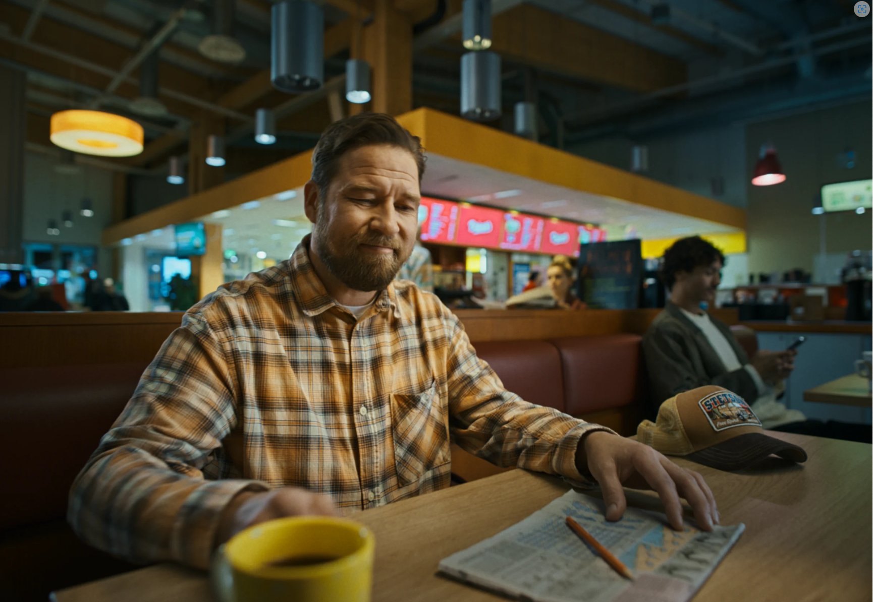 Henkilö lukee lehteä huoltoasemalla.