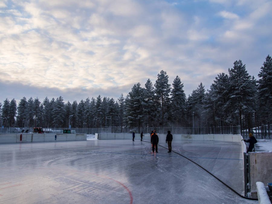 Mies suihkuttaa vettä ulkojäälle.
