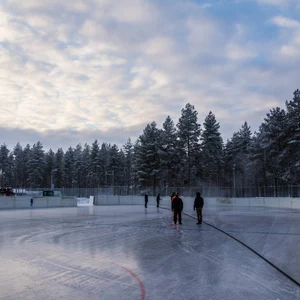Mies suihkuttaa vettä ulkojäälle.