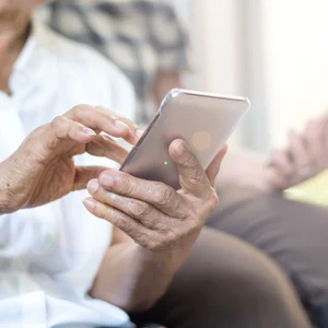 Två personer med mobiltelefon ringer St1