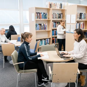 Ihmisiä kirjastossa.