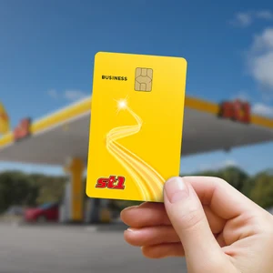 En hand håller ett St1Business-kort framför en St1 station