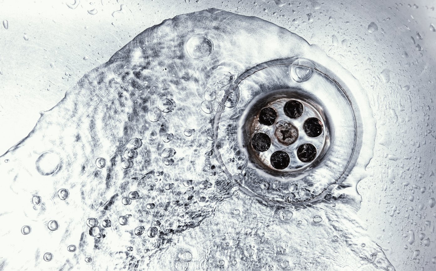 Wasser fließt in einen Abfluss