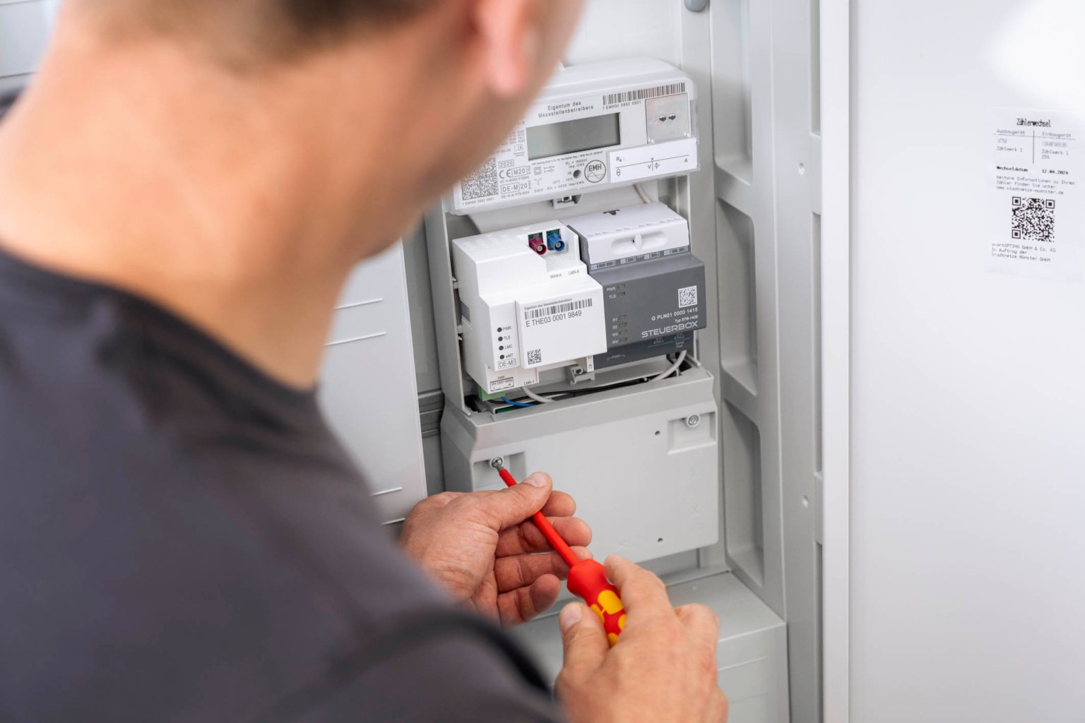 Monteur installiert einen Smart Meter mit Steuerbox