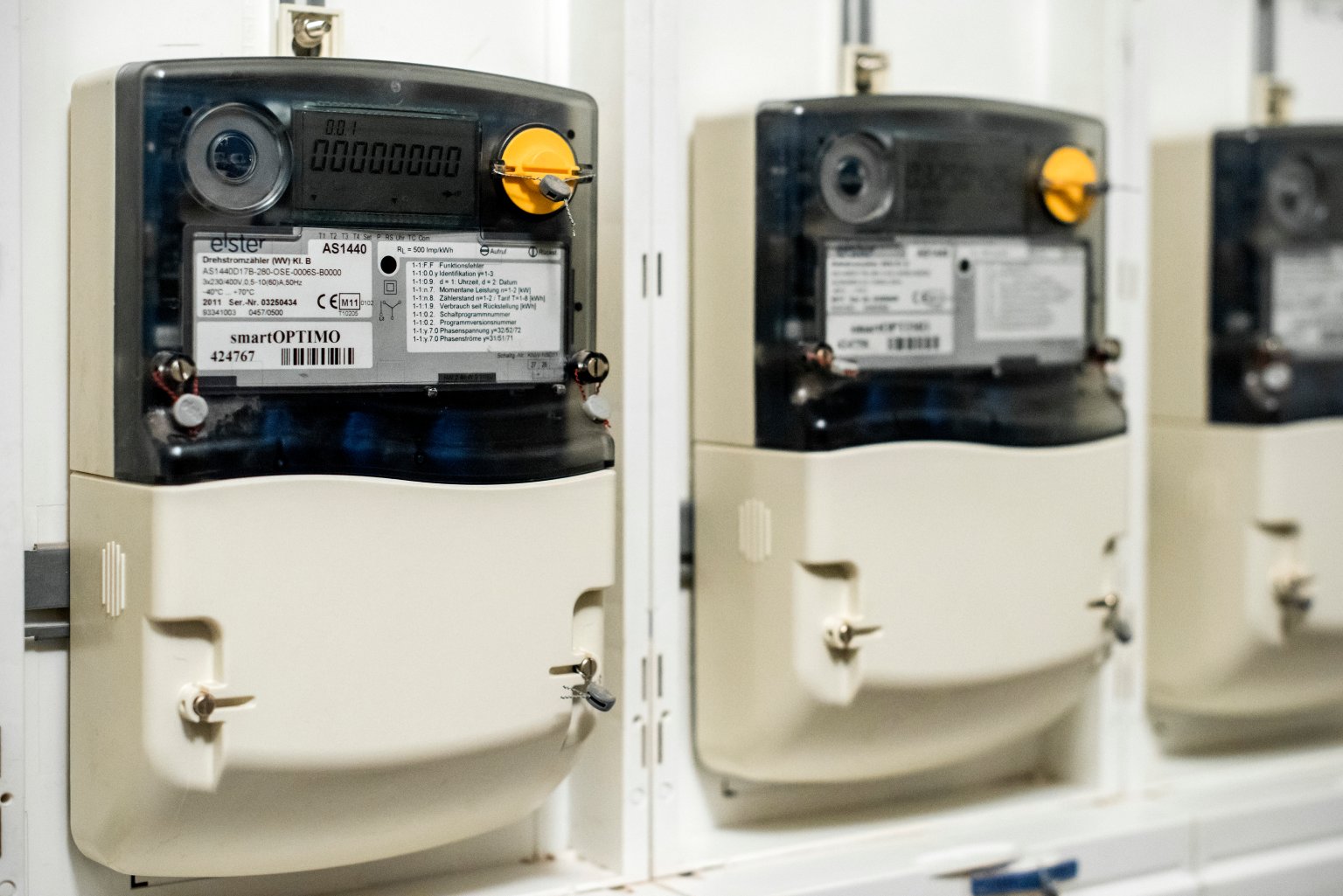 Zähler für Strom, drei Stromzähler nebeneinander an einer Wand montiert