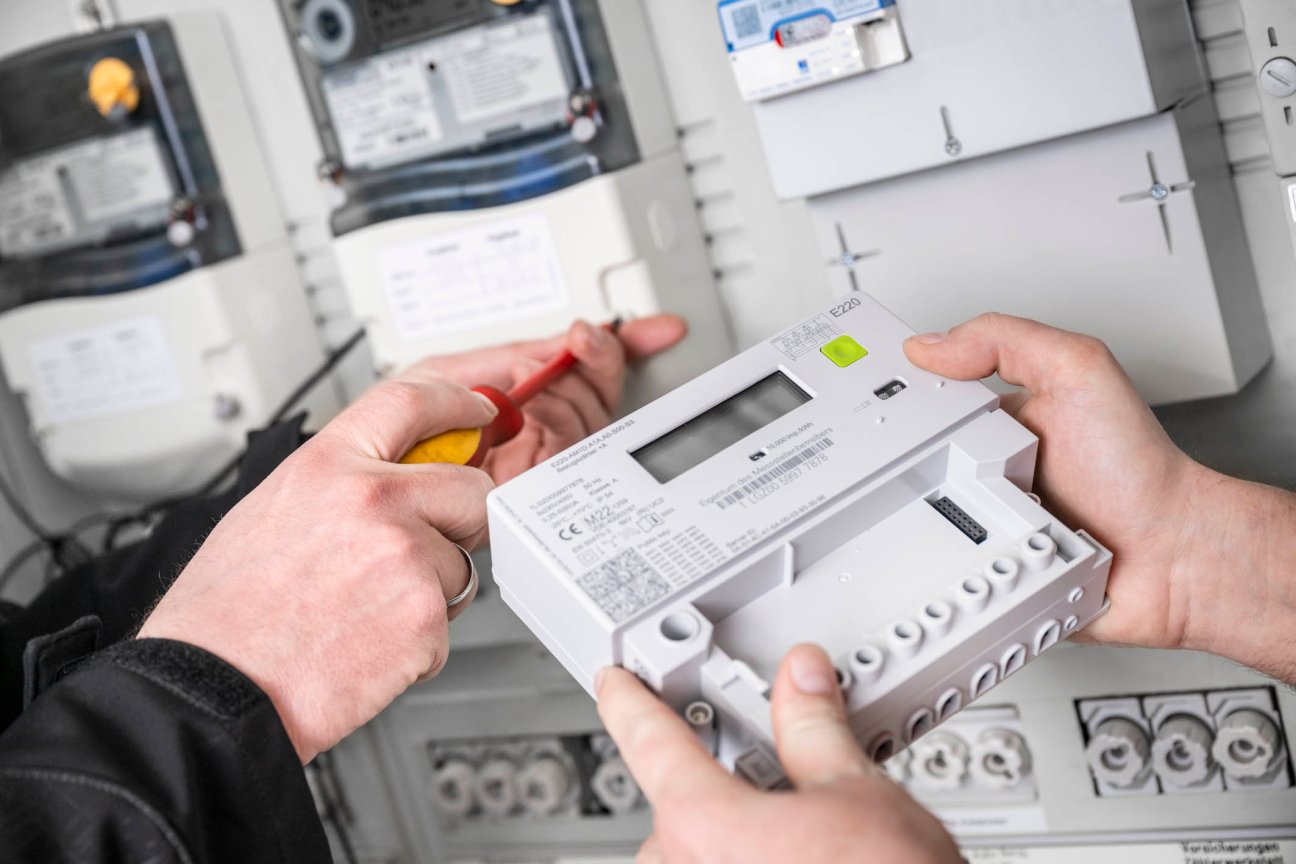 Zwei Personen installieren einen Smart Meter.
