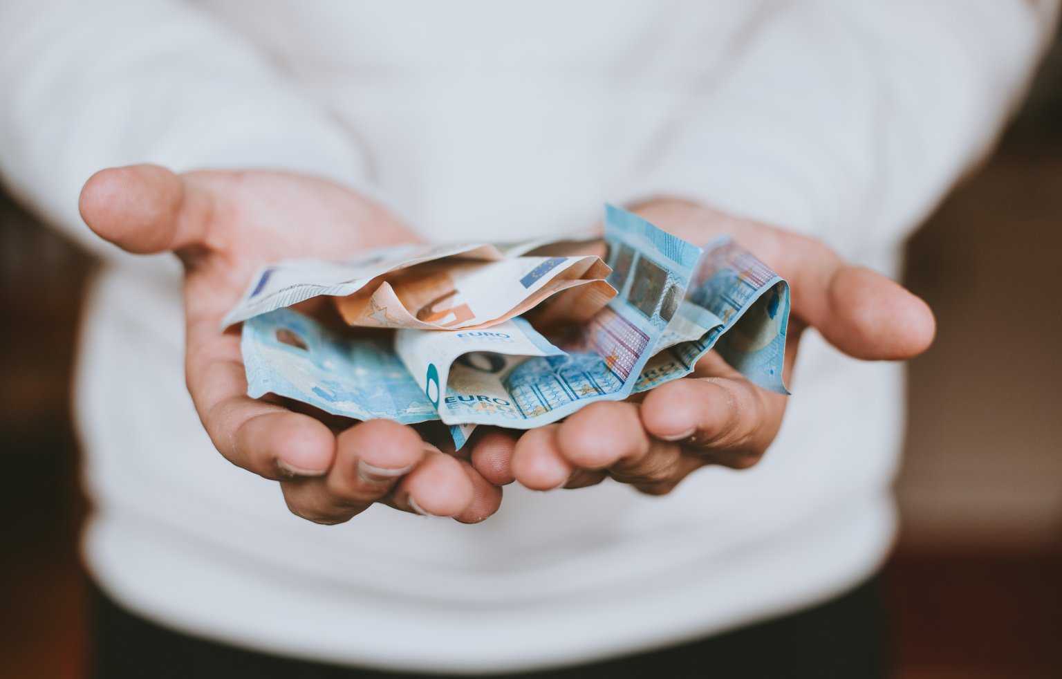 Mensch hält Geld in der Handfläche