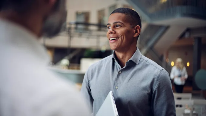 Man talking to colleagues smiling