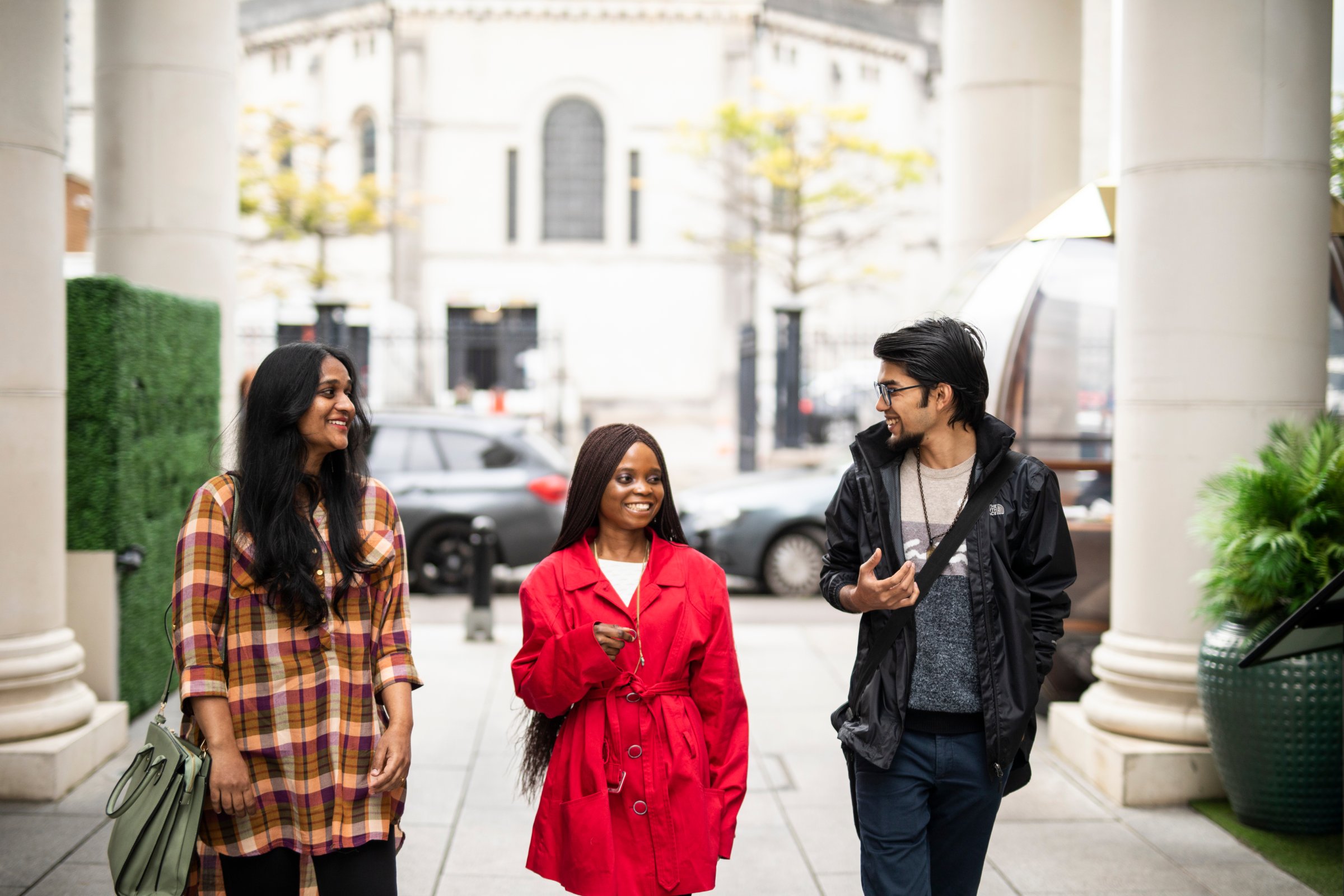 Three international students walking together and chatting