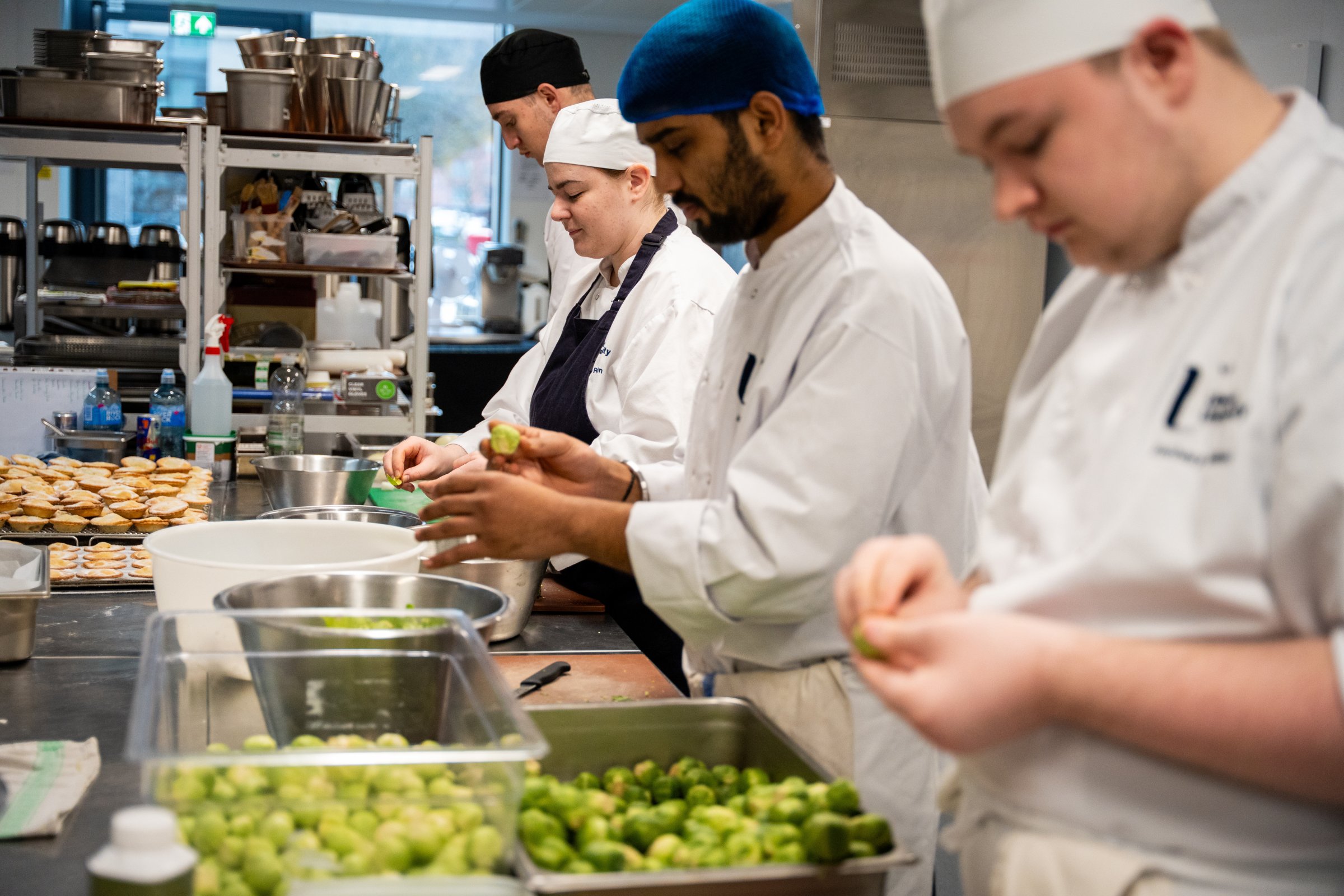 Culinary students preparing fresh ingredients in the Academy Restaurant training kitchen.