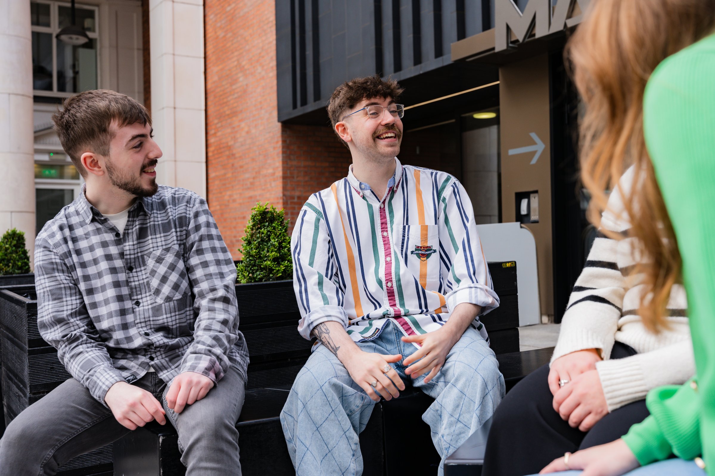 Two male students chatting to a group