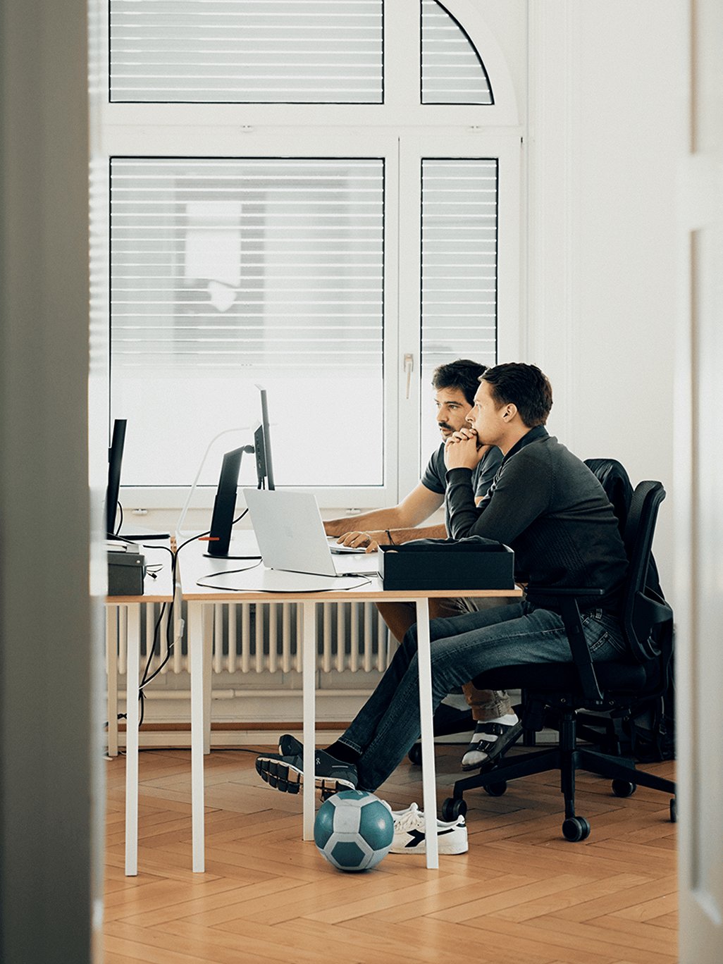 Two Frontify employees around a computer