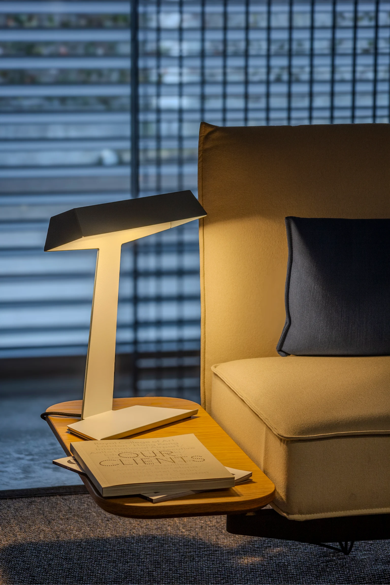 Taluna Desk Luminaire in yellow on a couch table.