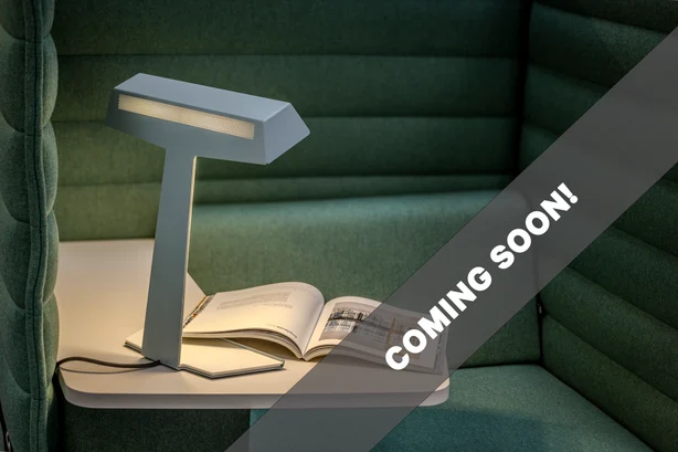 TALuna desk luminaire in front of a green couch.