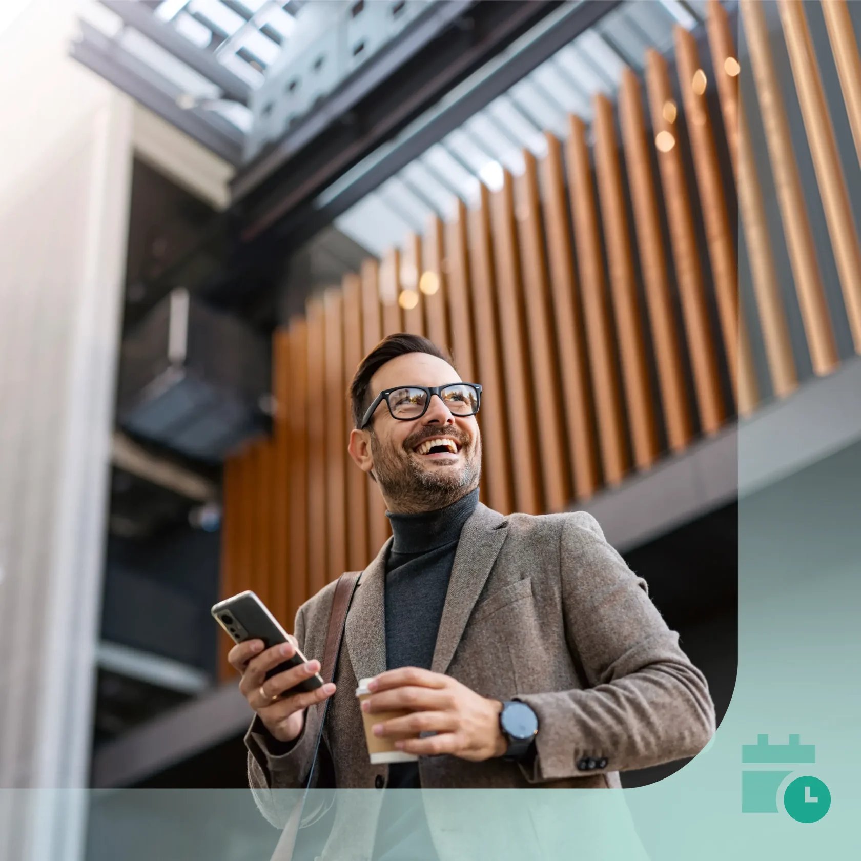 Smiling professional holding a smartphone and coffee outside a modern office building.
