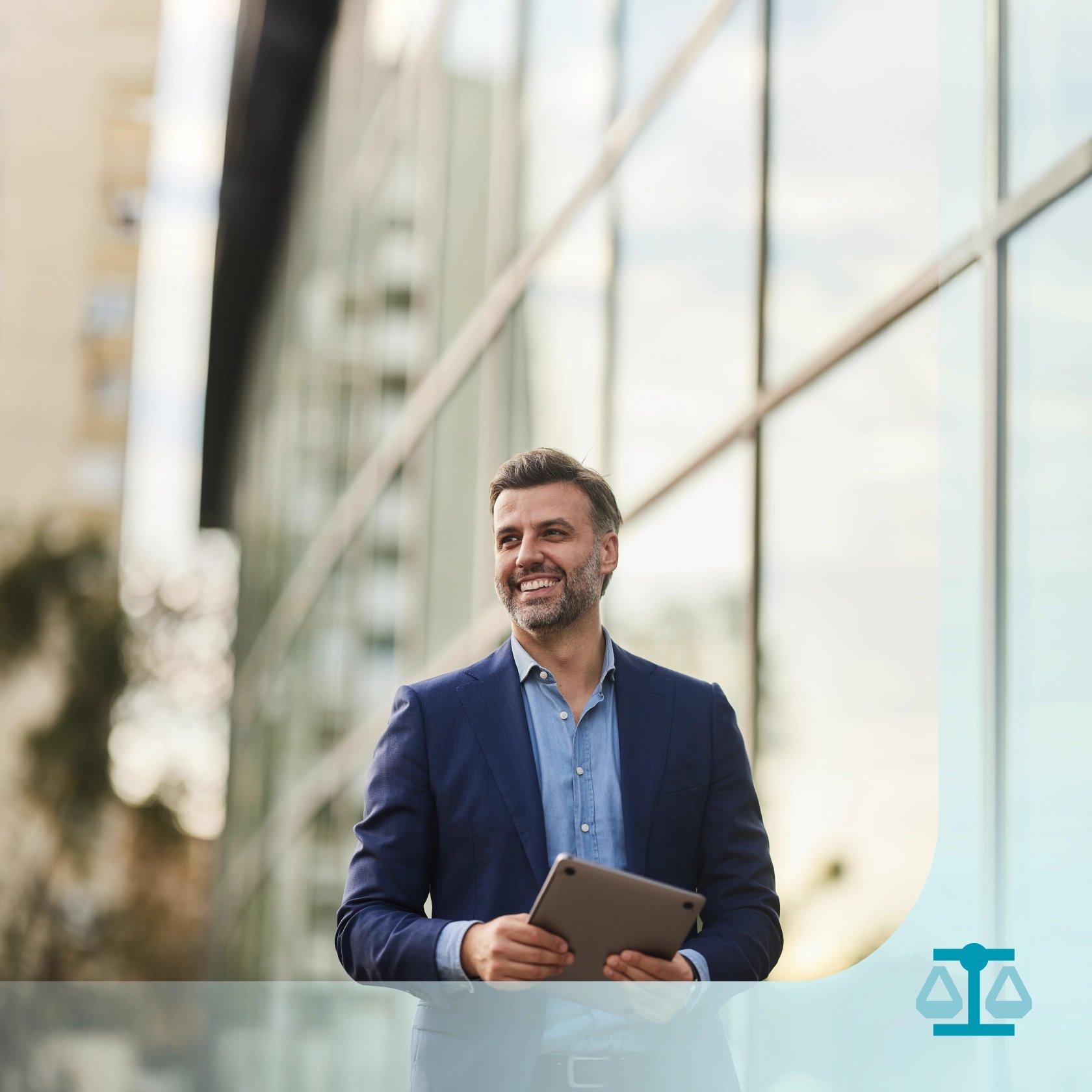 A man in a blue suit, likely an immigration lawyer, holds a tablet and smiles while standing outside a modern glass building.