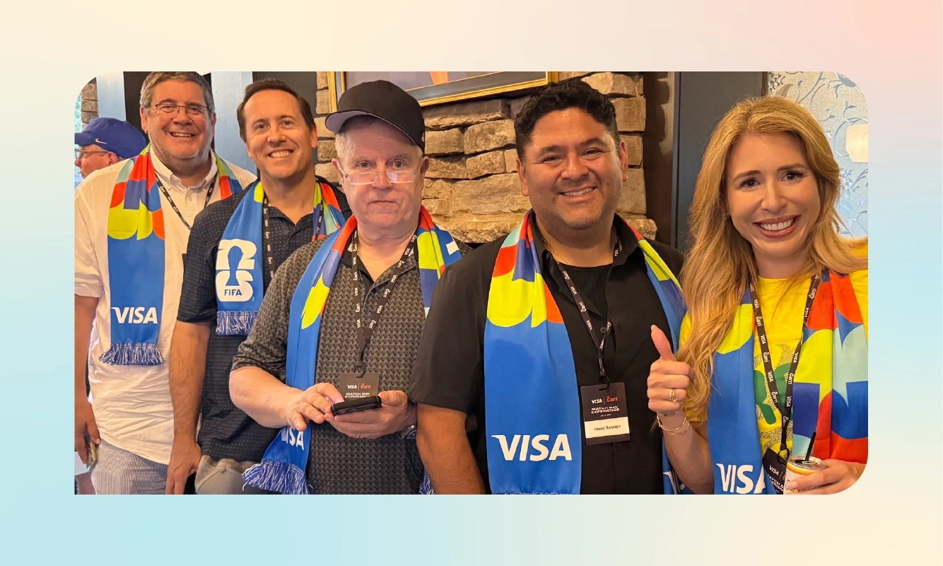 A group of attendees pose together wearing Visa-branded scarves ahead of the FIFA World Cup 2026 match.