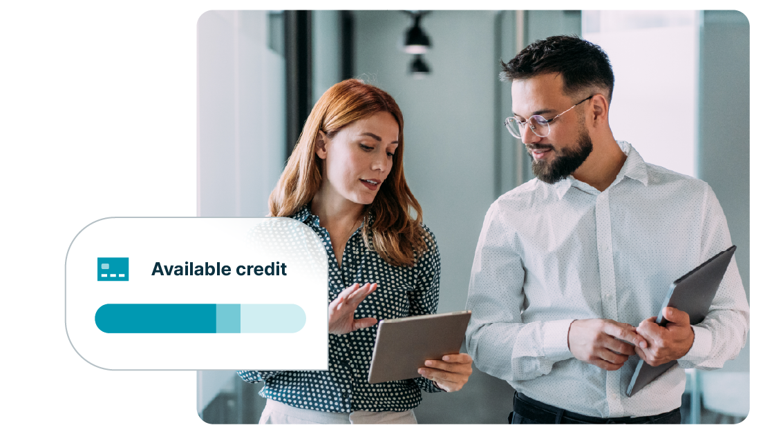 Two professionals review financial information on tablets in an office while a dashboard graphic displays available credit with a progress bar, representing business credit tracking and financial management.