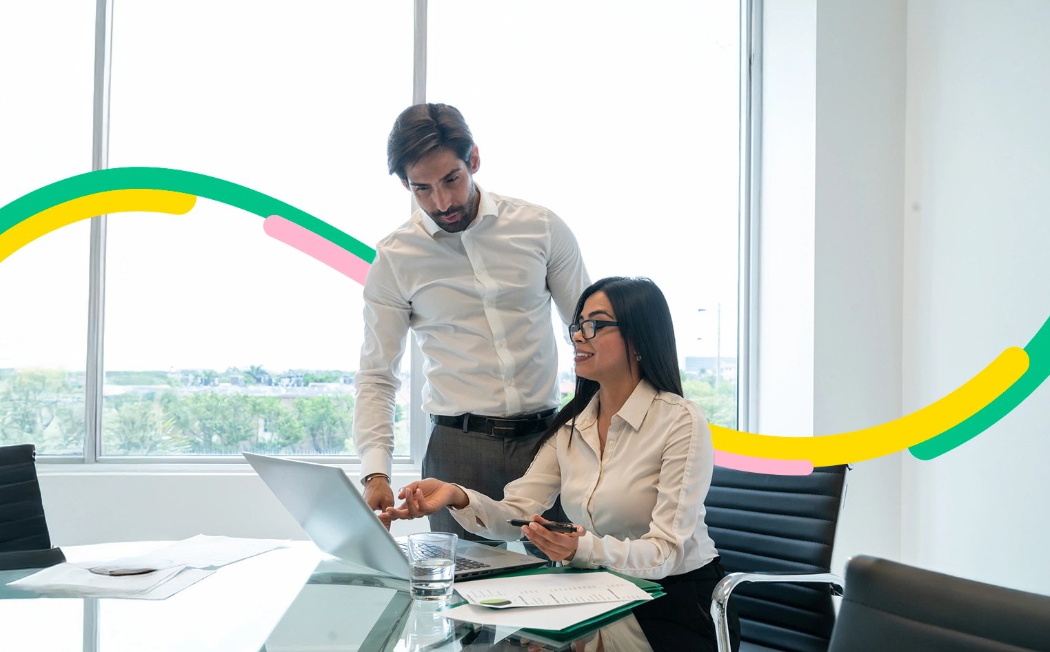 Dos personas en una oficina revisan los productos de financiación que ofrecemos en Bancolombia.