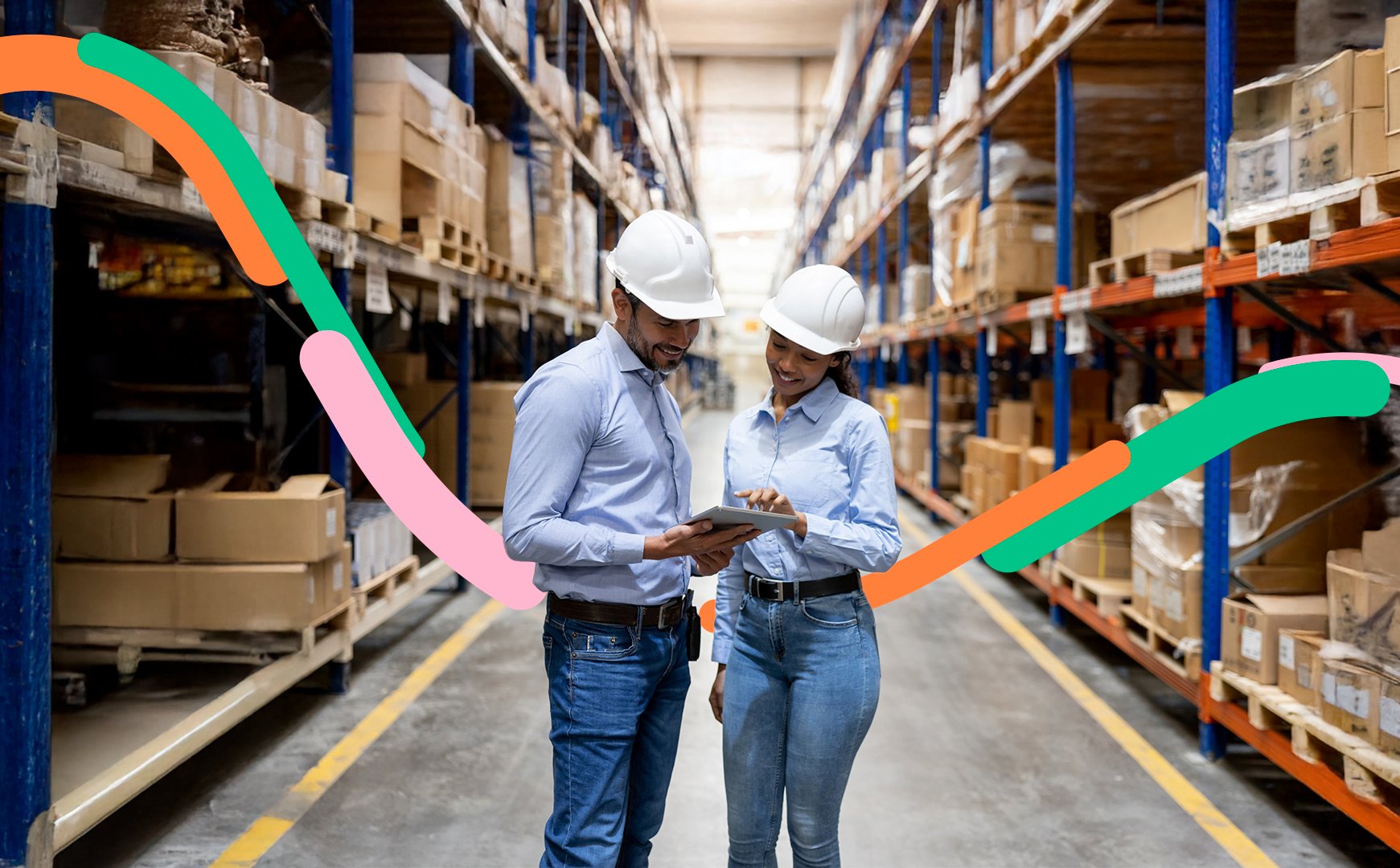 Dos compañeros de trabajo en una bodega usan casco y hacen inventario de los paquetes que su empresa envía y recibe.