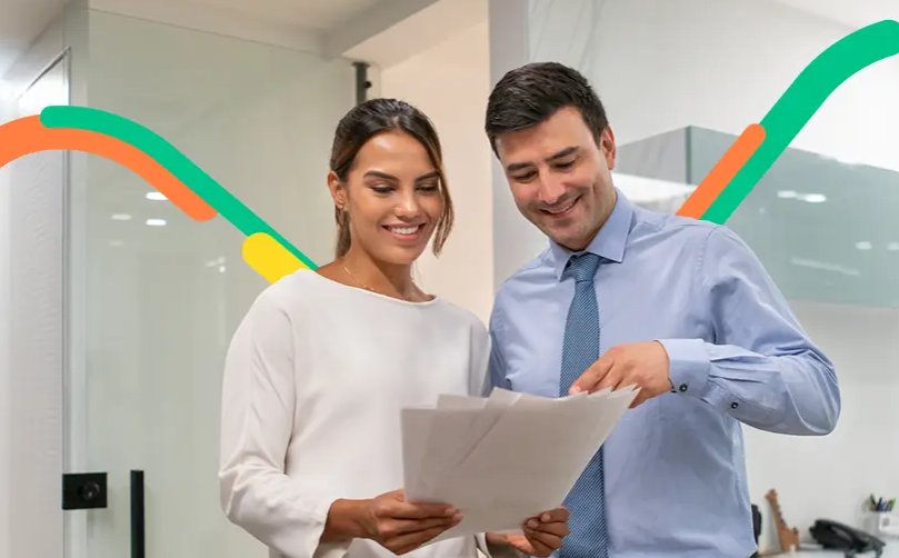 Asesor y cliente revisan documentos financieros en una oficina para comercial internacionalmente.