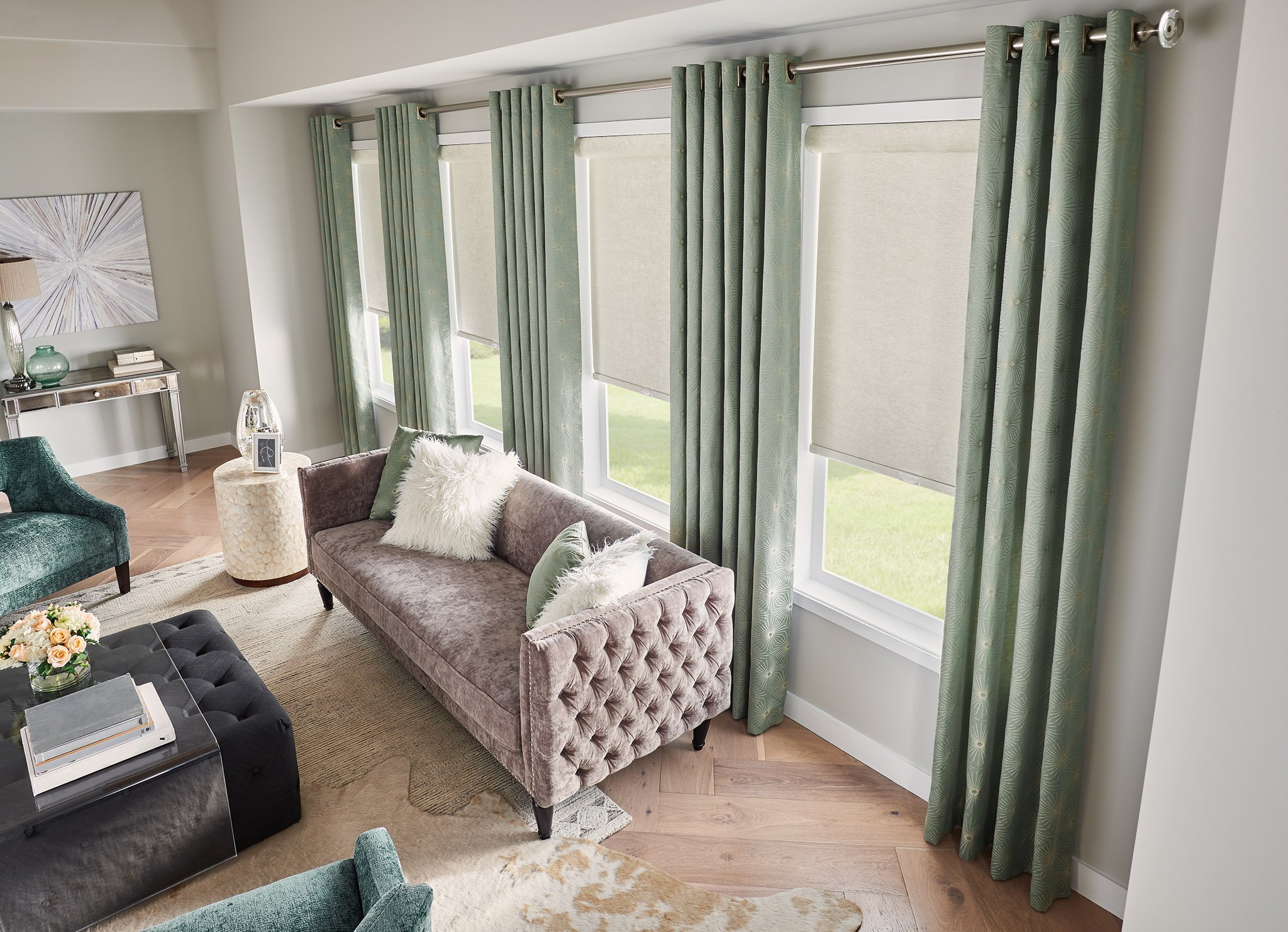 Beige roller shades paired with green drapery to give a layered look in living room