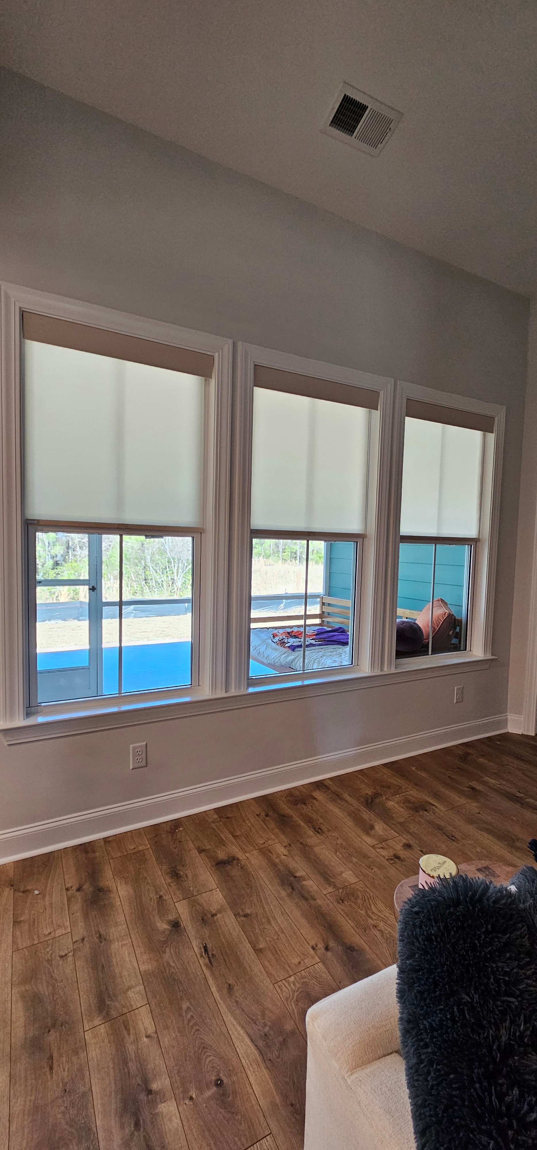 shades-roller-tan-triple-windows-living-room-deck-view