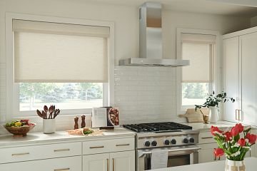 Cream colored roller shades in kitchen