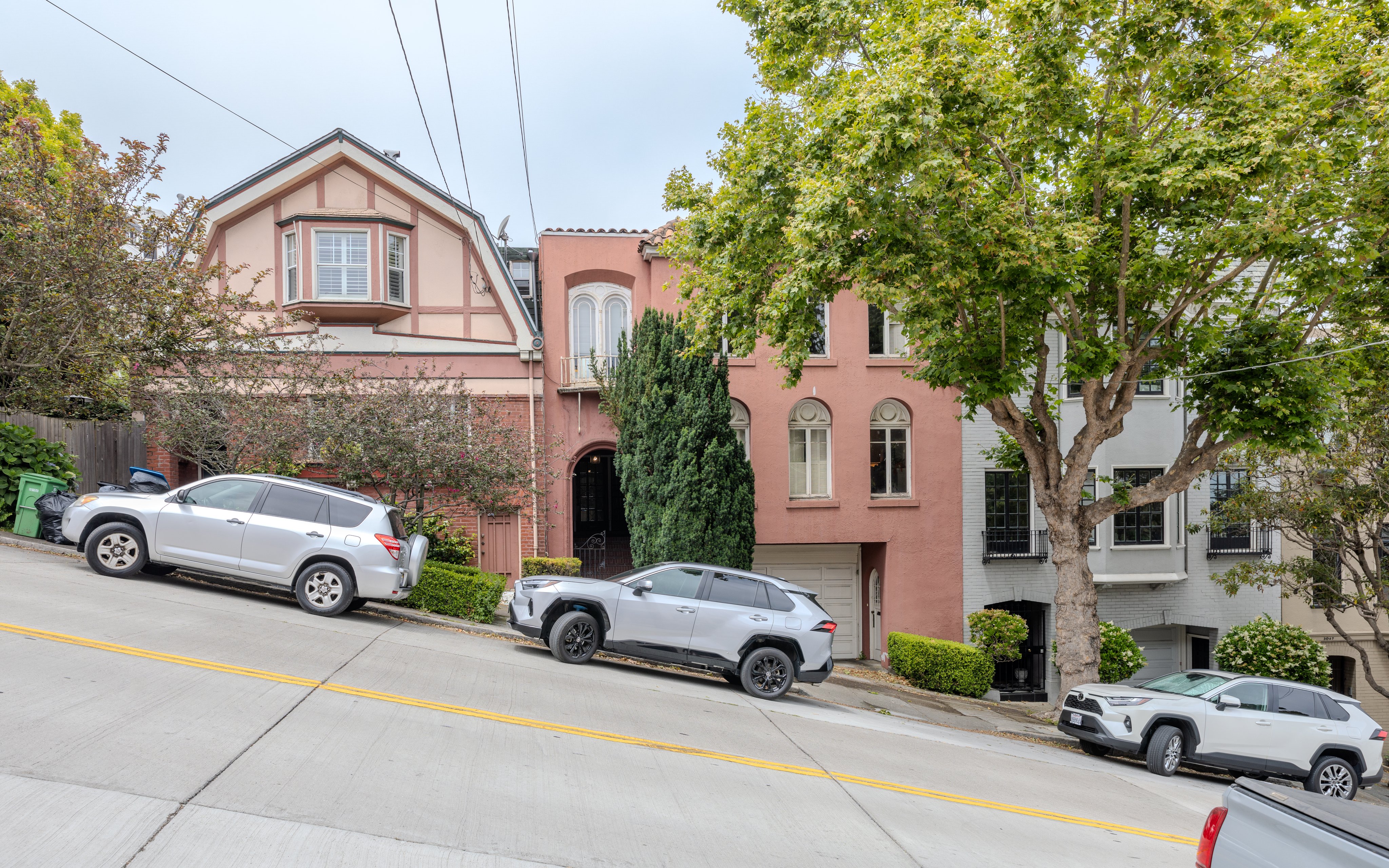 San Francisco, California is very hilly, many streets are quite steep, it takes some skill to properly parallel park the car with front wheels turned to rest on the curb, as seen here in Cow Hollow neighborhood.