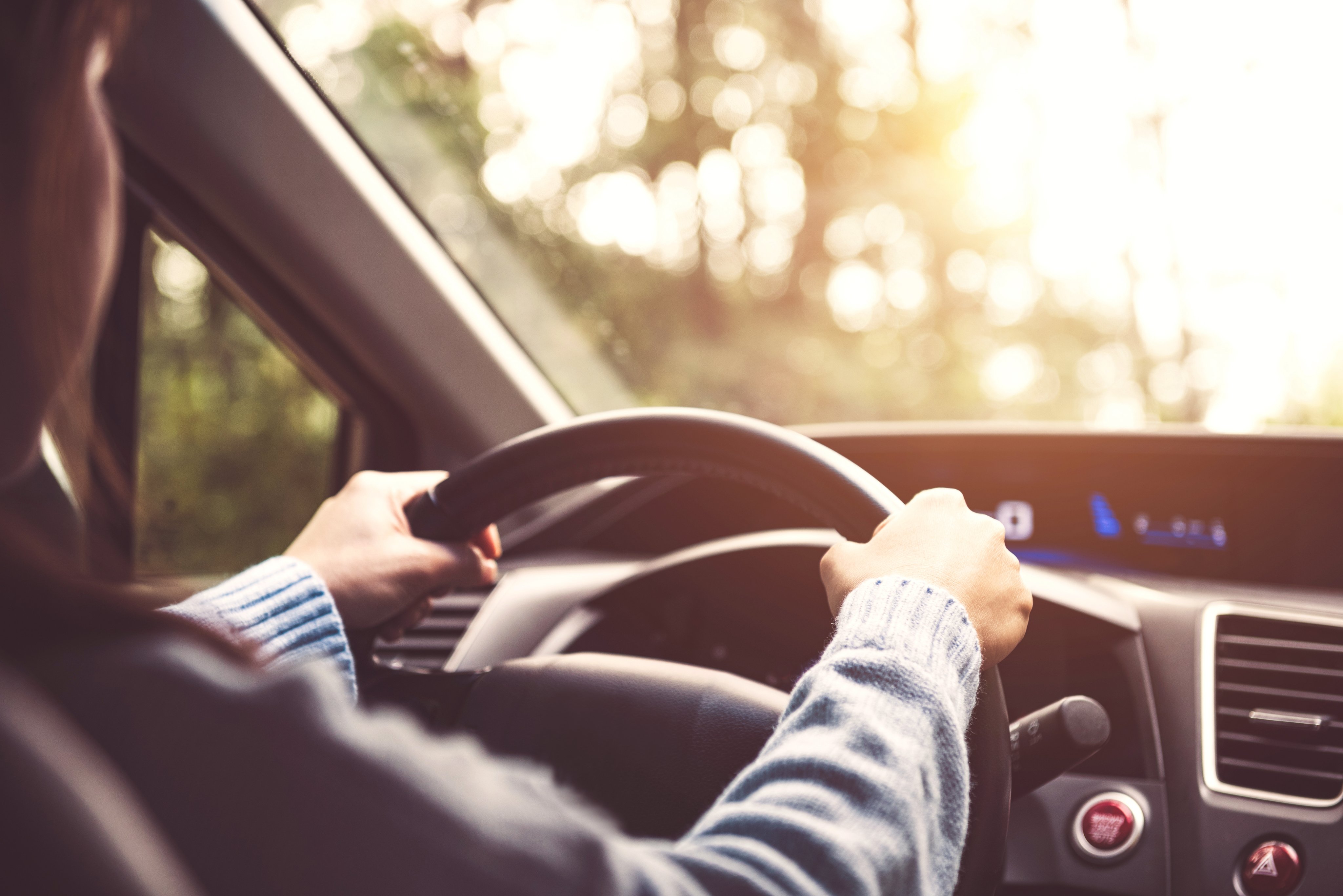 Person driving with both hands on the wheel