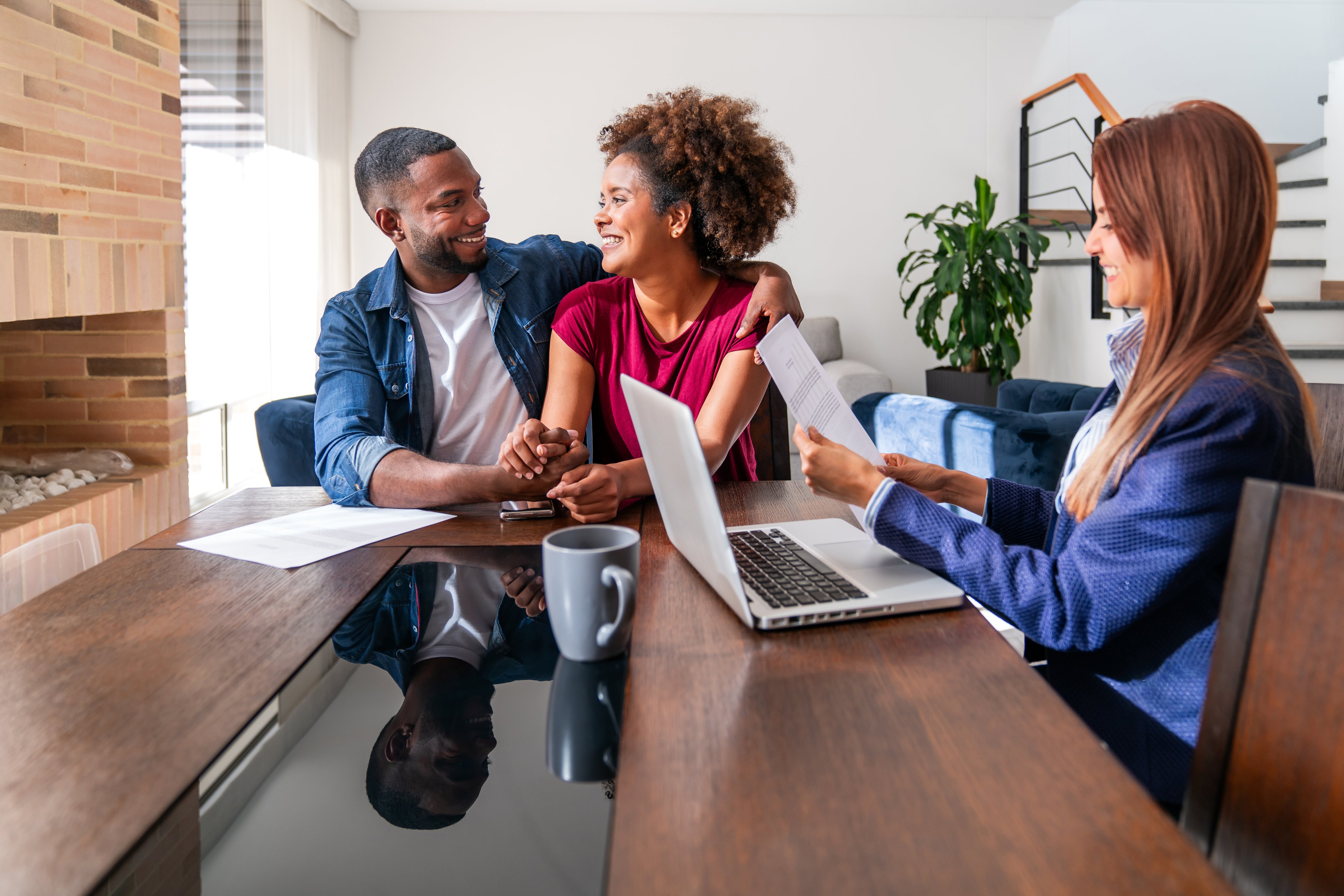 Couple looking very excited switching insurance with an agent and sorting the paper work