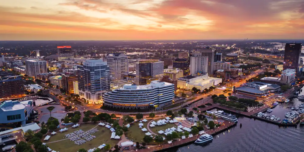 Norfolk, Virginia, USA downtown city skyline from over the Elizabeth River at dusk